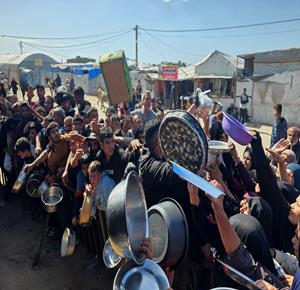 نازحون يتجمعون  للحصول على وجبات طعام من مطبخ خيري في خان يونس جنوب قطاع غزة